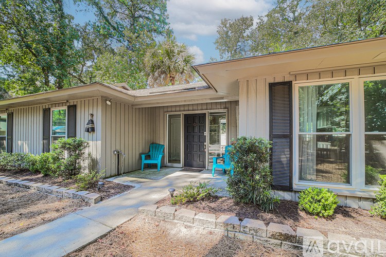 A house with a blue chair on the front porch.