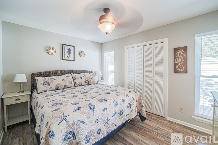 A bedroom with a bed, nightstand, and two pictures on the wall.