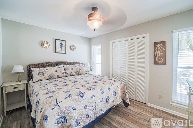 A bedroom with a bed, nightstand, and two pictures on the wall.