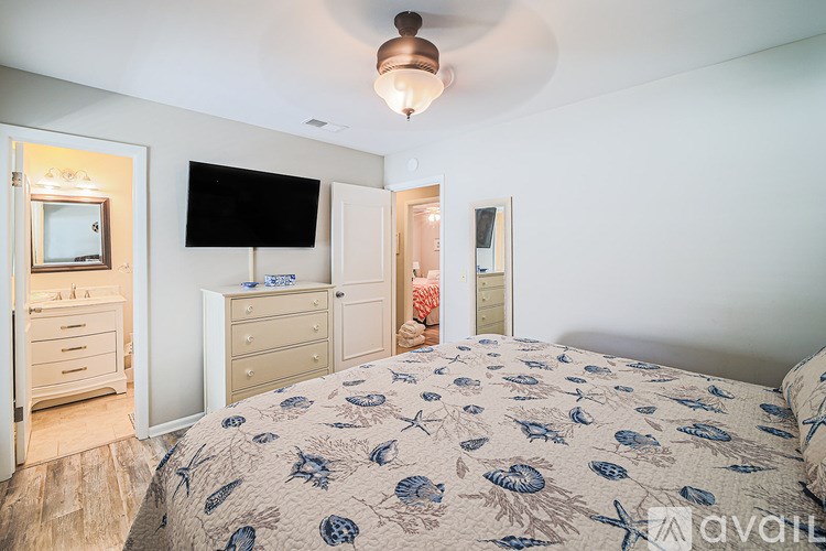 A bedroom with a bed, dresser, and television.