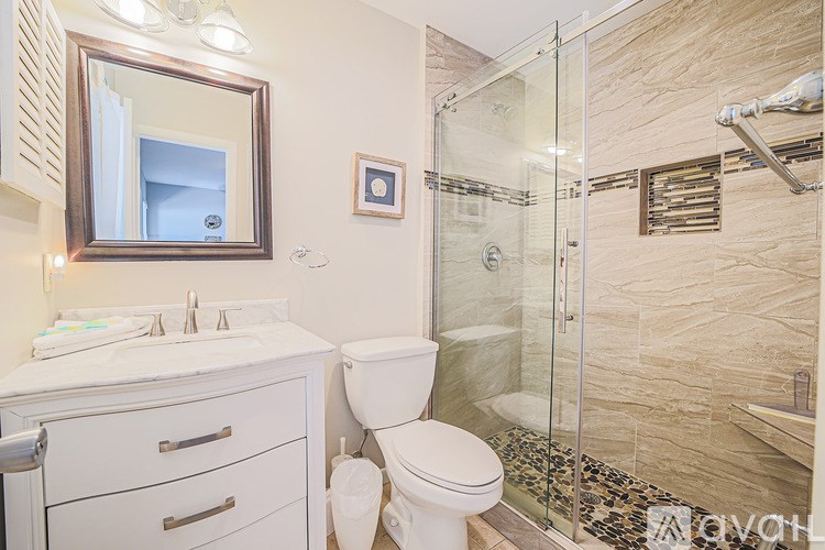 A bathroom with a toilet, sink, and shower.