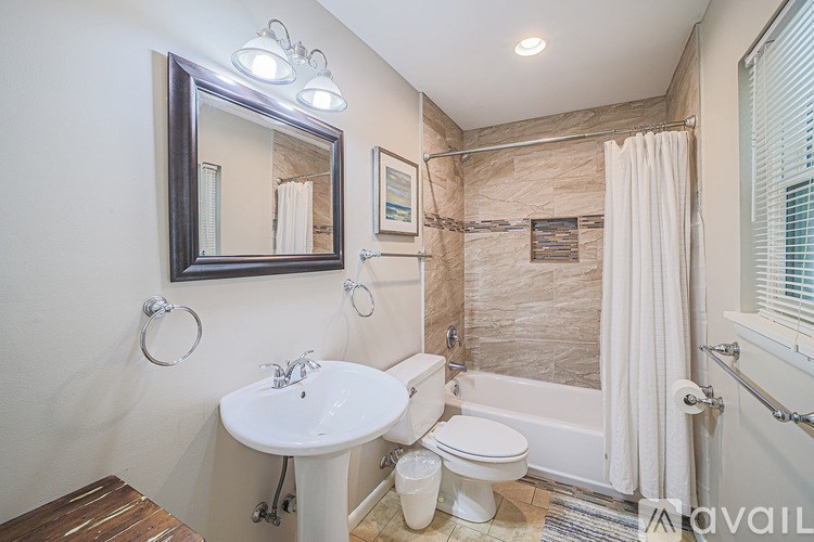 A bathroom with a toilet, sink, and shower.