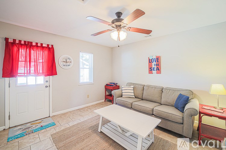 A living room with a couch, a coffee table, and a ceiling fan.