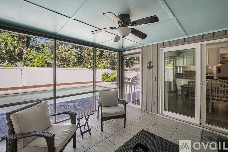 A patio with a ceiling fan and a table with two chairs.