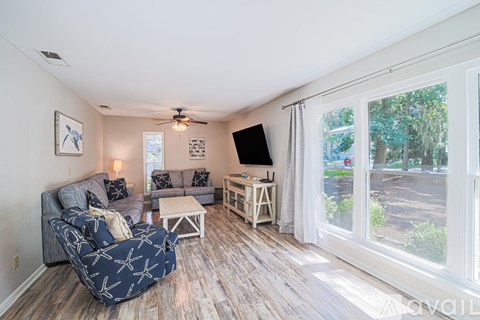 A living room with a grey couch and a black and white patterned sofa.