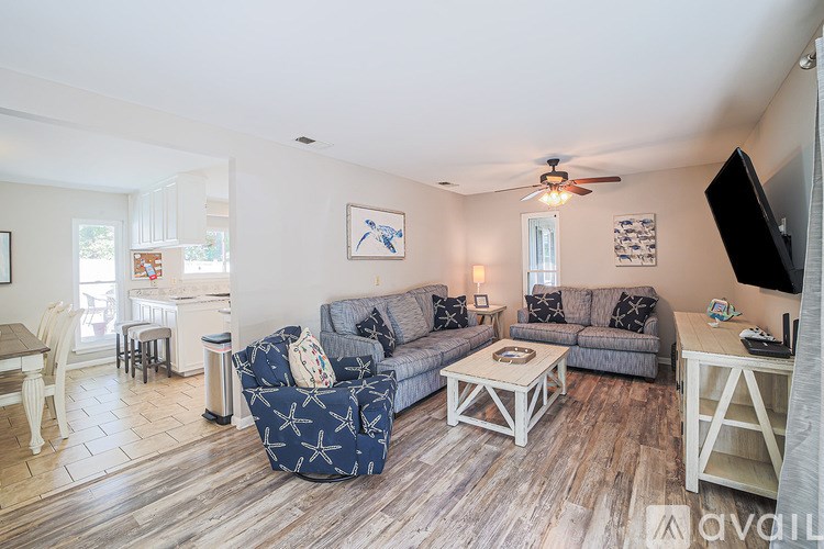 A living room with a grey couch and a wooden floor.