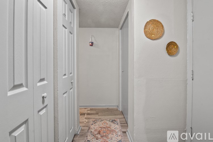 A hallway with a rug and two circular decorations on the wall.