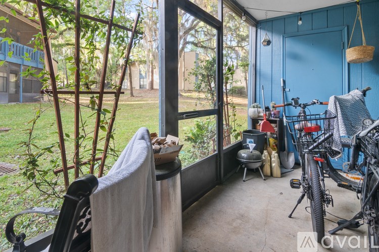 A patio with a chair and a table with a tablecloth on it.