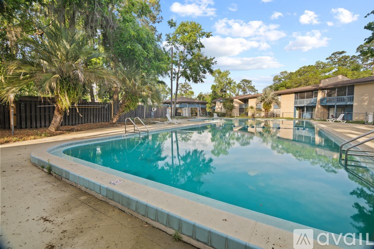 A swimming pool surrounded by trees and a fence.