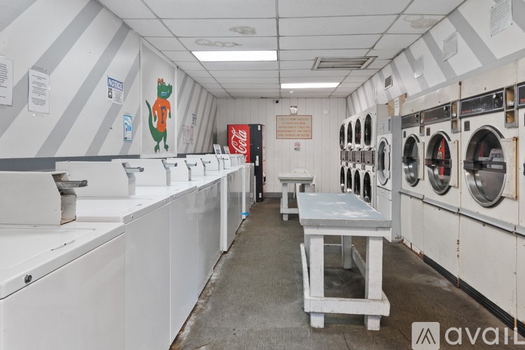 A laundromat with a row of washers and dryers.
