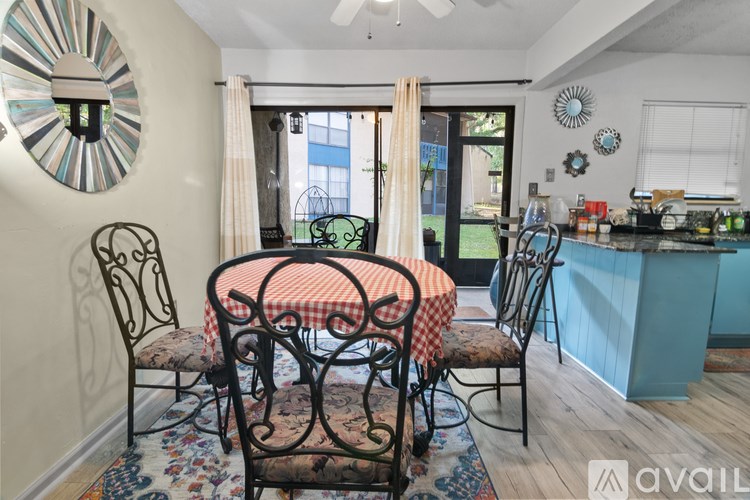 A kitchen with a table and chairs in front of a window.