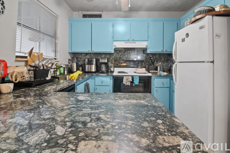 A kitchen with a marble countertop and blue cabinets.