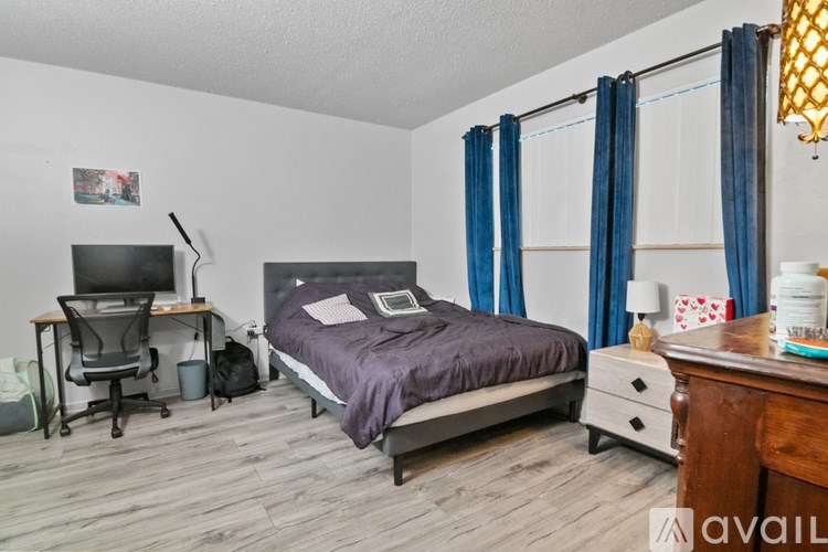 A bedroom with a bed, desk, and chair.