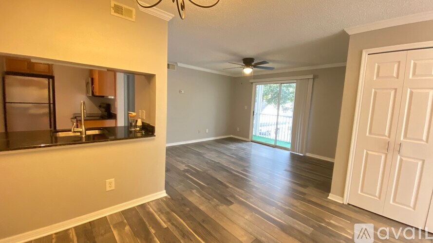 A room with wood flooring and a ceiling fan.
