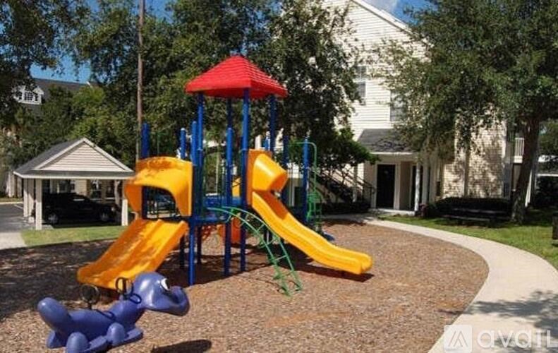 A playground with a yellow slide and a blue and red canopy.