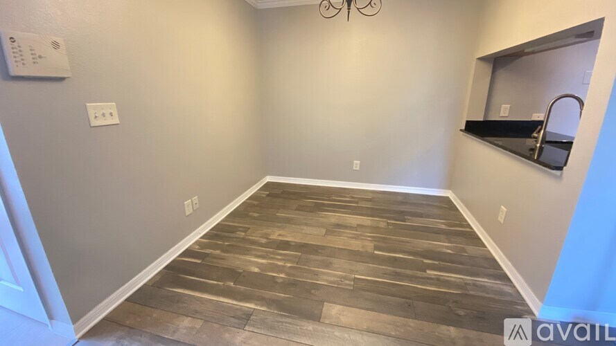 A room with wooden flooring and a mirror on the wall.