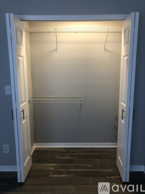 A small, empty closet with a light on.
