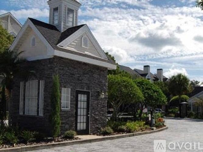 A house with a tower and a driveway in front.
