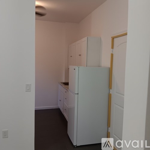 A kitchen with white appliances and cabinets.