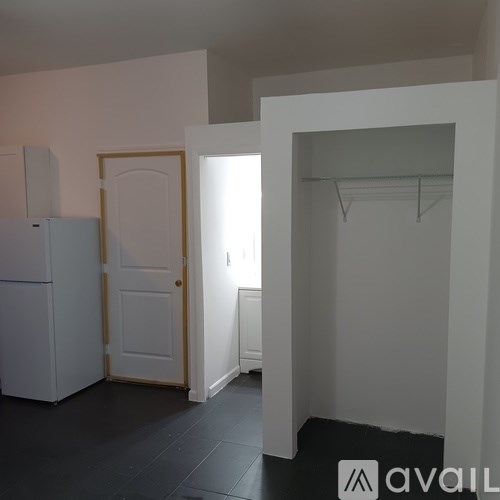 A kitchen with a white fridge and a white door.