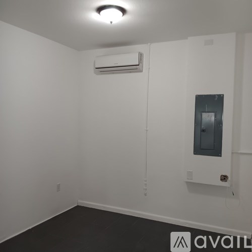 A room with a white wall and a black floor.