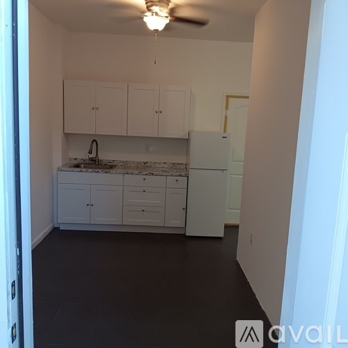 A kitchen with white cabinets and a marble countertop.