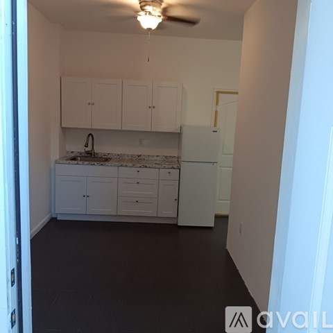 A kitchen with white cabinets and a marble countertop.