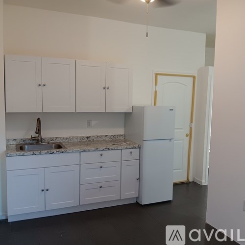 A kitchen with white cabinets and a marble countertop.