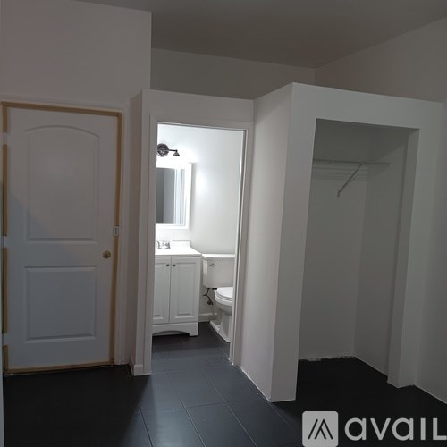 A bathroom with a toilet, sink and mirror.