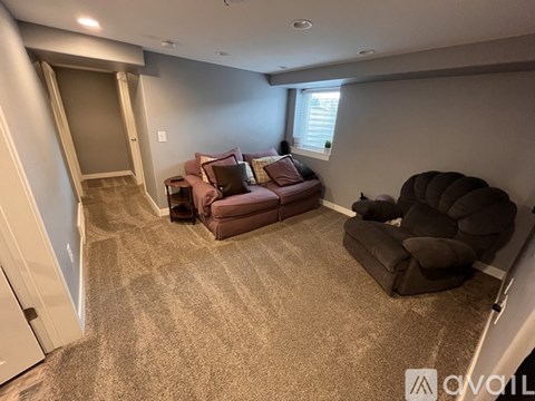 A living room with a brown couch and a brown chair.