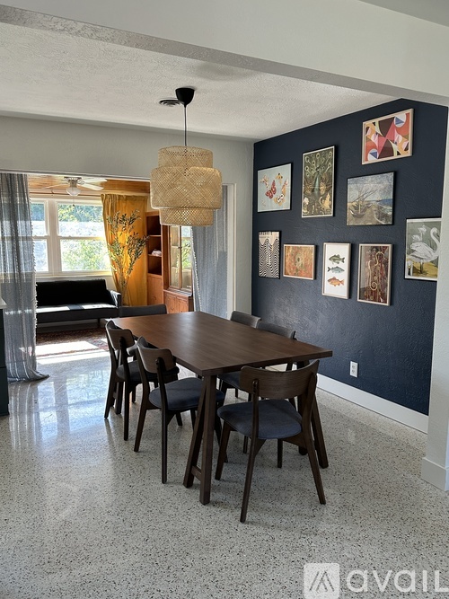 A dining room with a wooden table and chairs.