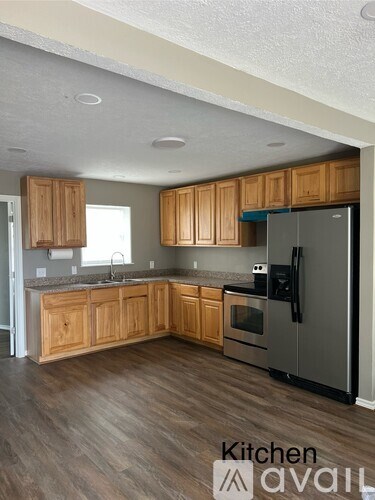 A kitchen with wooden cabinets and a refrigerator.