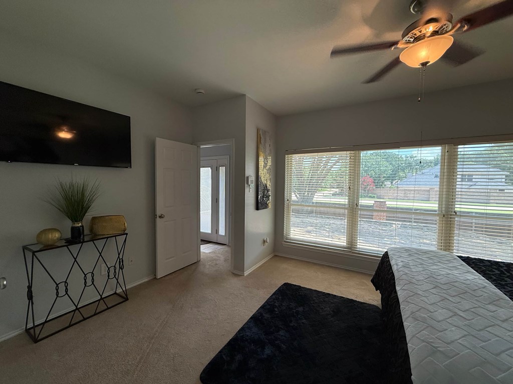 A living room with a flat screen TV mounted on the wall.