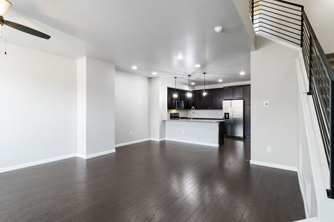 A spacious living room with a staircase on the right side.