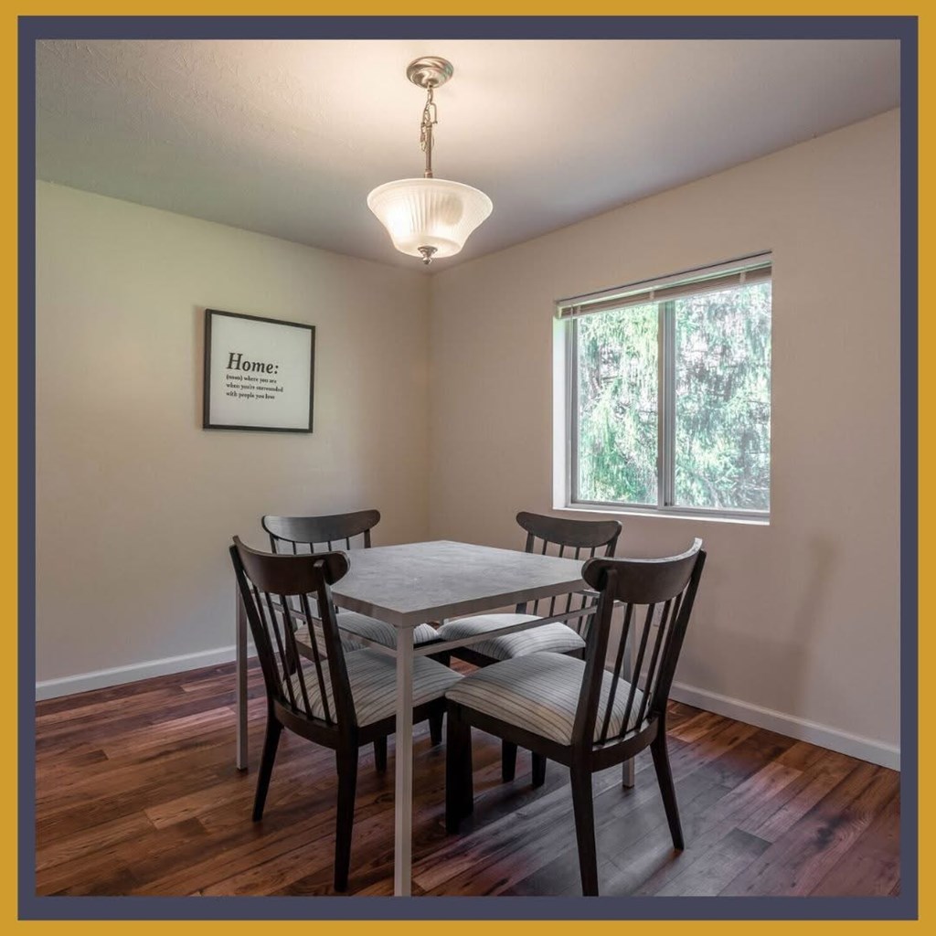 A dining room with a table and chairs.