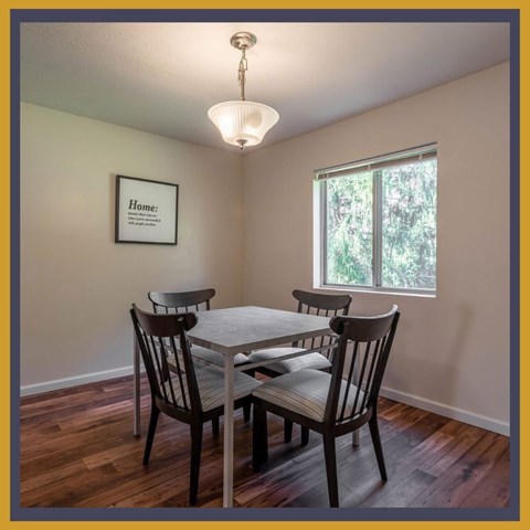 A dining room with a table and chairs.