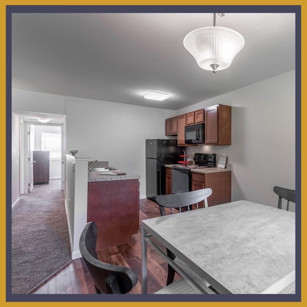 A kitchen with a refrigerator, microwave, and oven.
