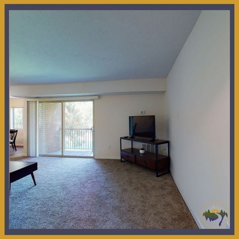 A living room with a television and sliding glass doors.