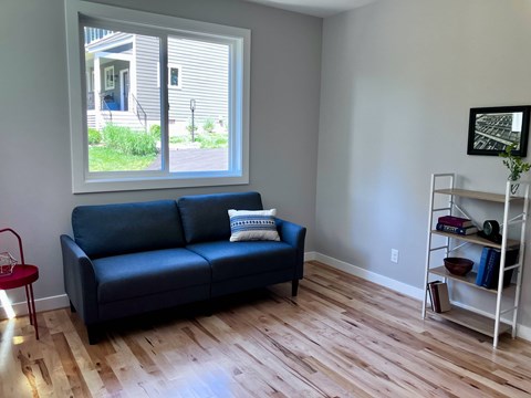 A living room with a blue couch and a red chair.