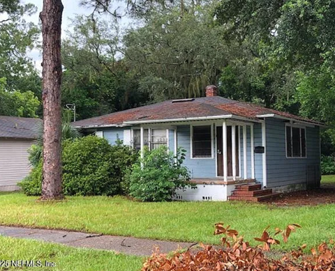 A small blue house with a porch and a red roof.