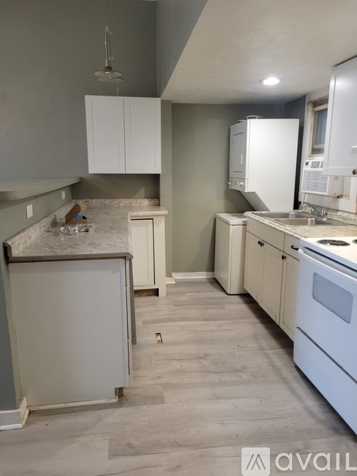 A kitchen with white appliances and cabinets is available for rent.