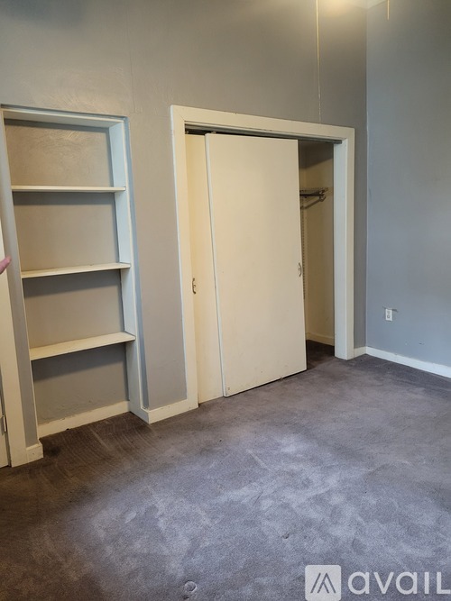 A room with a white door and a white shelving unit.