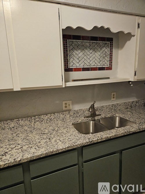 A kitchen with a sink and a backsplash.