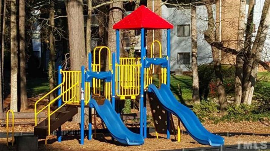 A playground with a blue slide and yellow railings.
