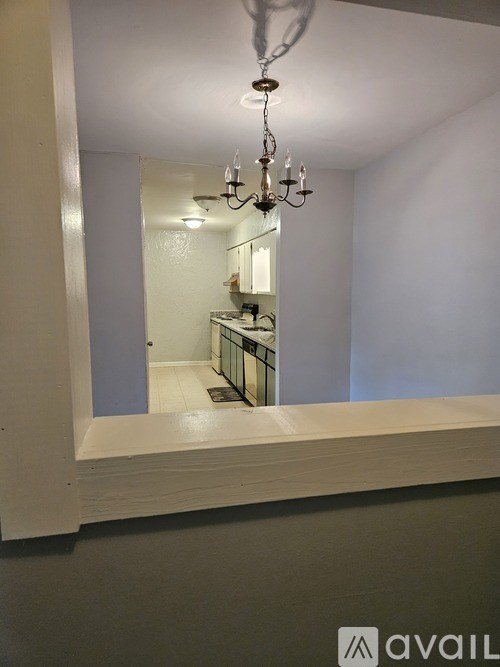 A mirror reflects a bathroom with a chandelier.