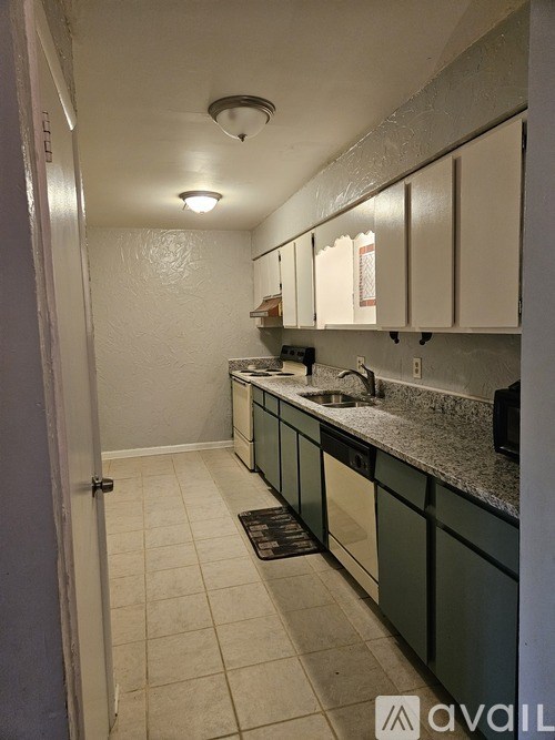 A kitchen with white cabinets and a black stove top oven.
