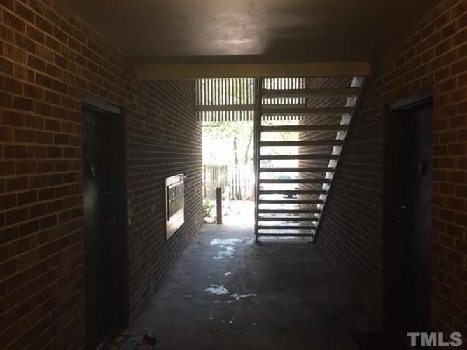 A long hallway with a staircase in the distance.