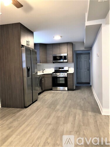 A kitchen with a refrigerator, sink, and cabinets.