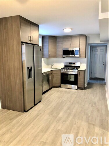 A kitchen with a refrigerator, oven, and microwave.