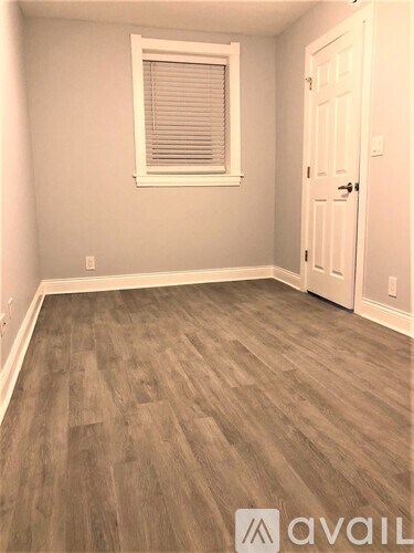 A room with a wooden floor and a white door.